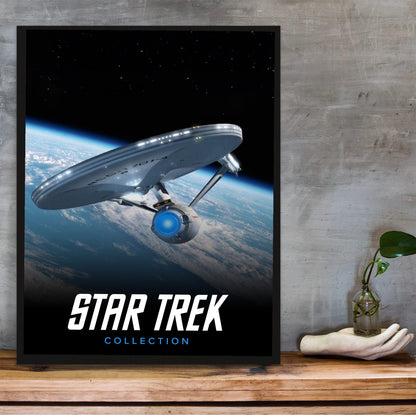 Star Trek TV Collection Art poster in a black frame on a wooden shelf against concrete