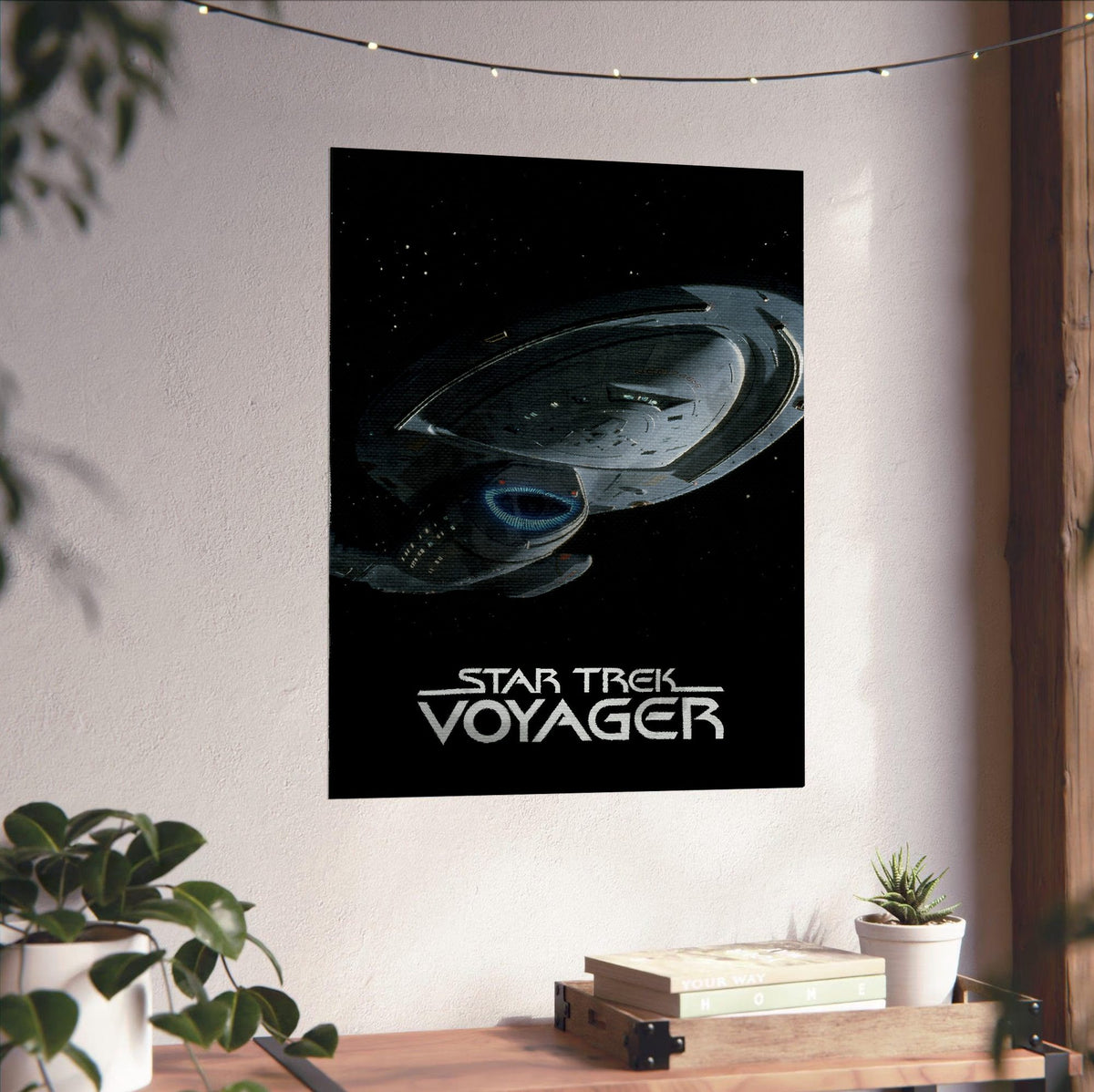 Star Trek: Voyager poster unframed on a white wall above a desk