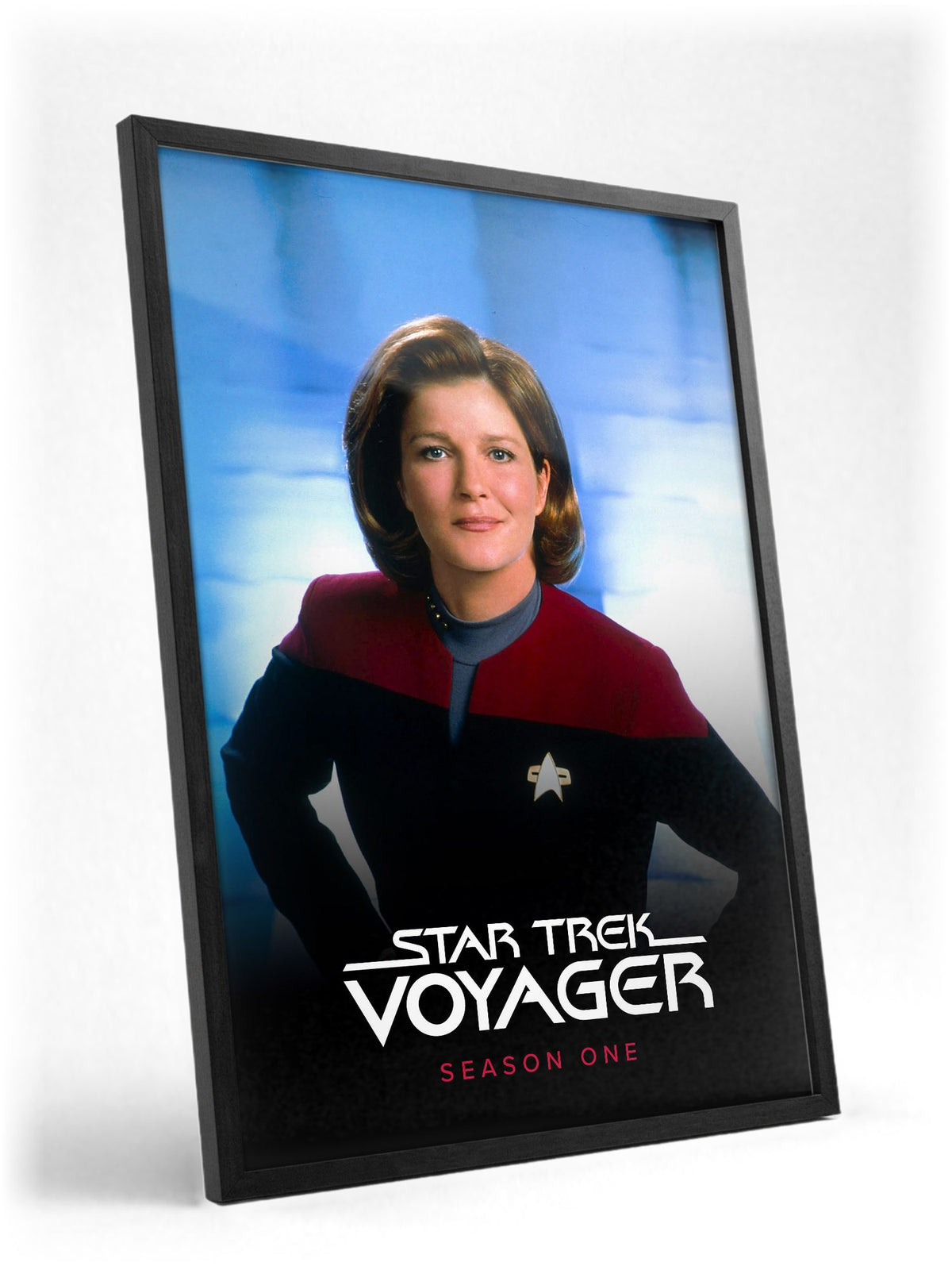 Star Trek: Voyager poster in a black frame with glass leaning against a wall