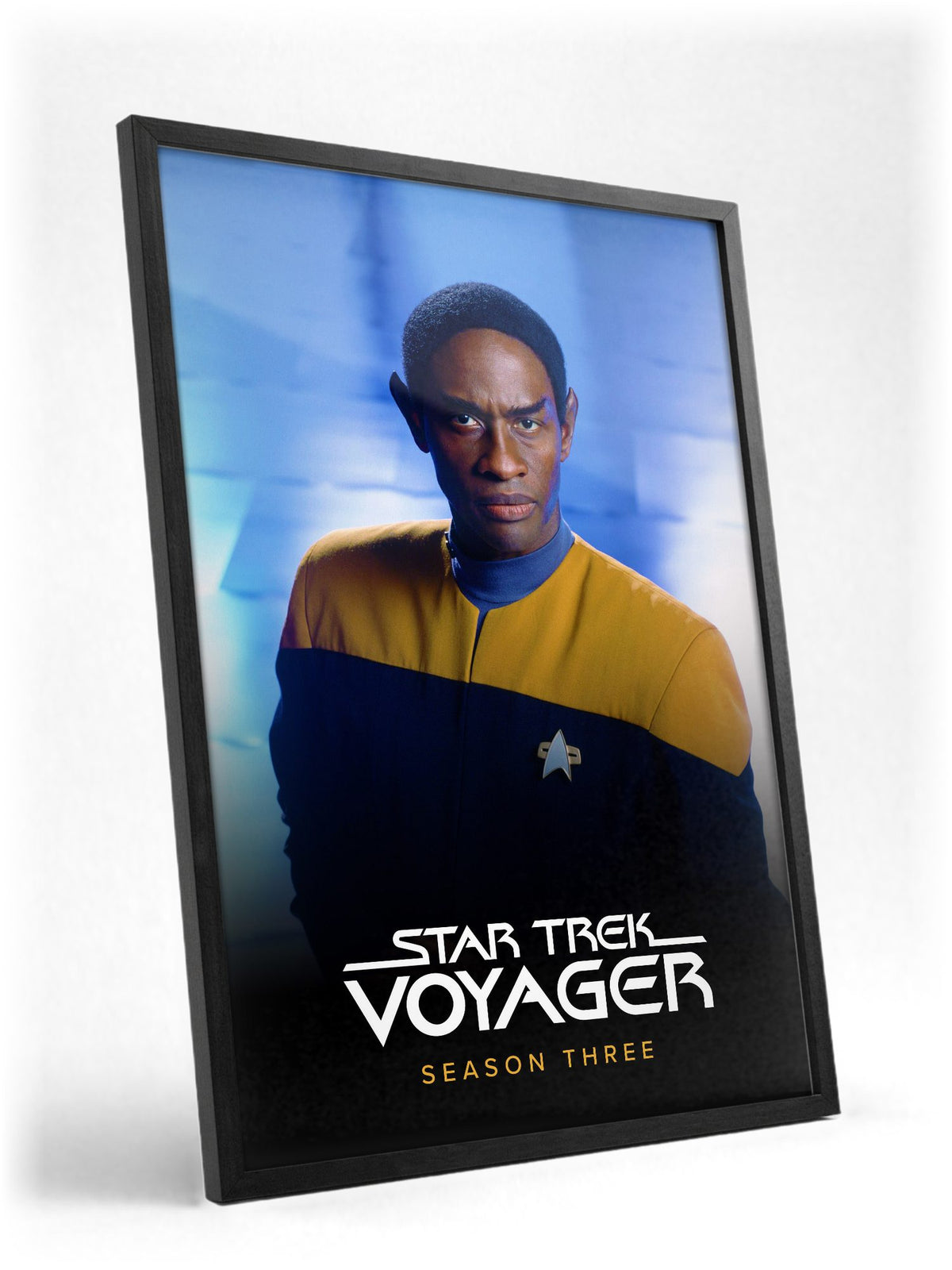 Star Trek: Voyager poster in a black frame with glass leaning against a wall