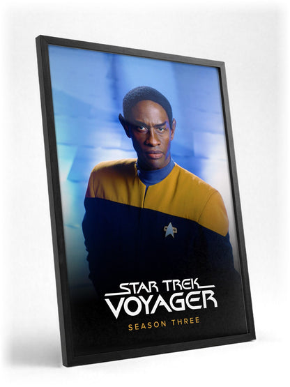 Star Trek: Voyager poster in a black frame with glass leaning against a wall