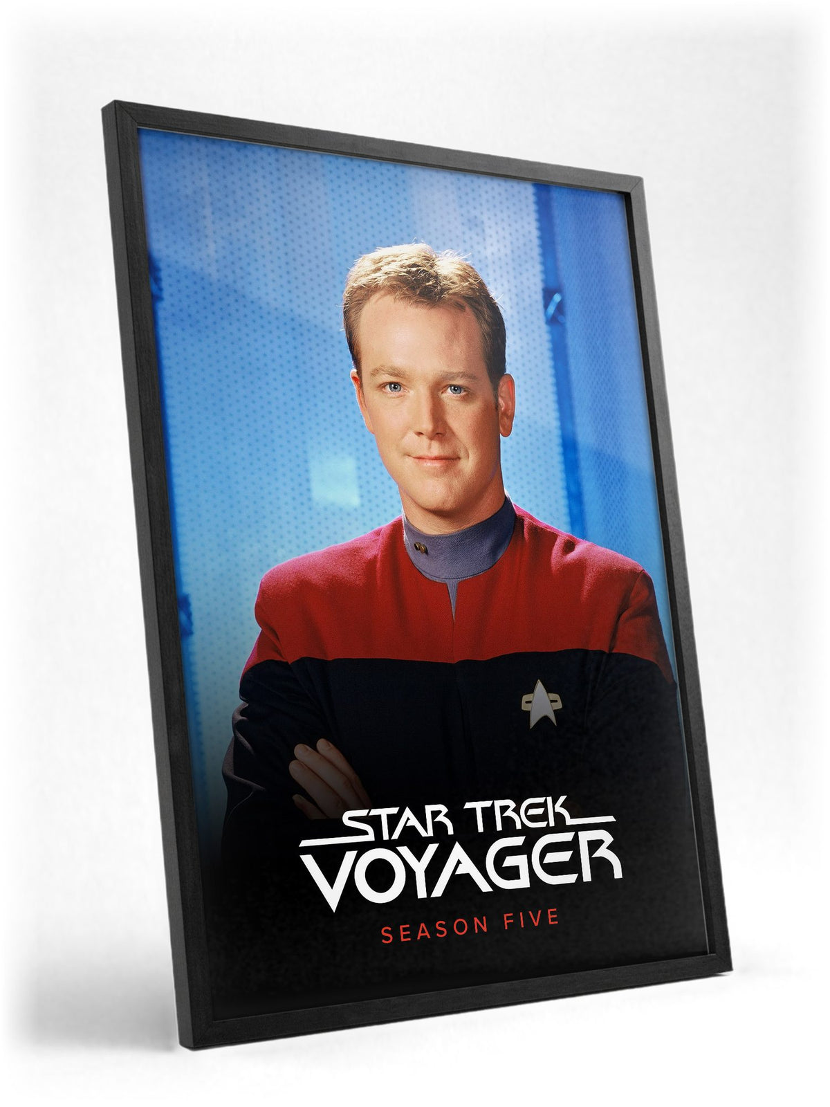 Star Trek: Voyager poster in a black frame with glass leaning against a wall