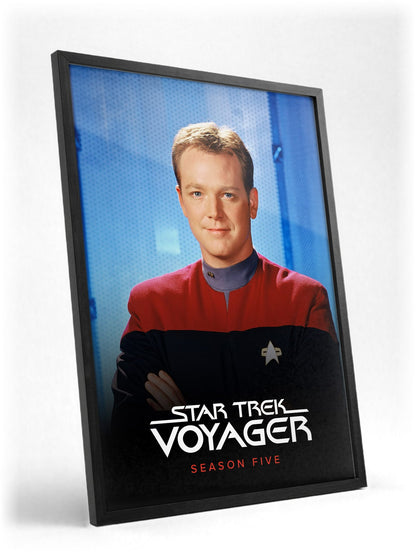 Star Trek: Voyager poster in a black frame with glass leaning against a wall