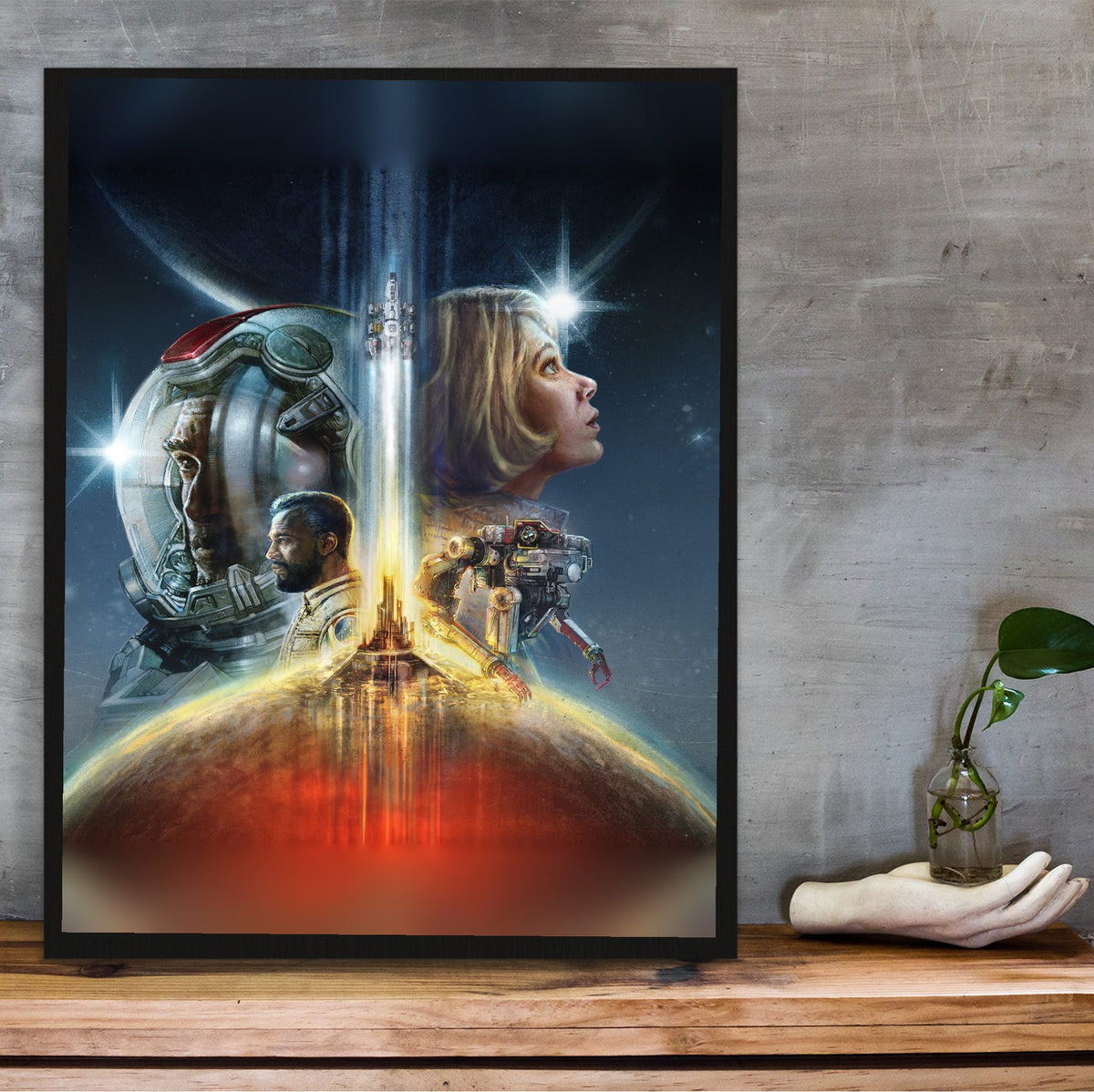Starfield Key Art poster in a black frame on a wooden shelf against concrete