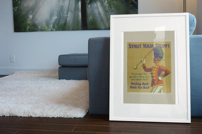 Strut Your Stuff poster in a white frame leaning beside a blue sofa