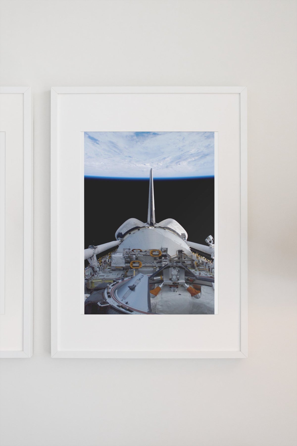 STS-123 Space Shuttle leaving the ISS poster in a white frame on a light wall
