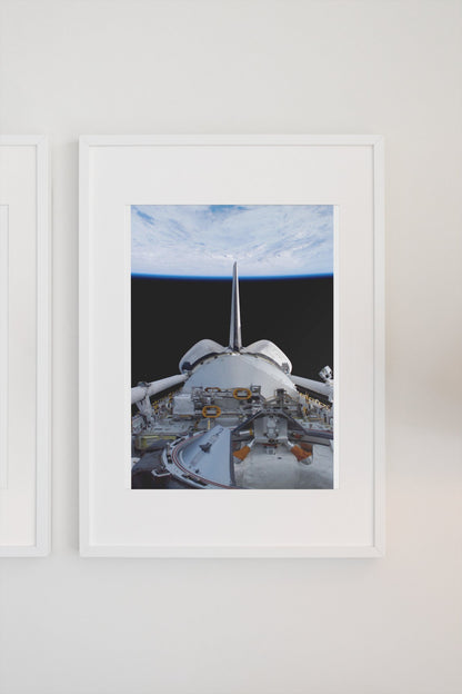 STS-123 Space Shuttle leaving the ISS poster in a white frame on a light wall