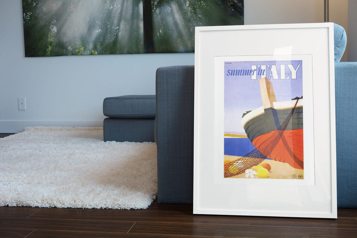 Summer in Italy poster leaning beside a blue sofa
