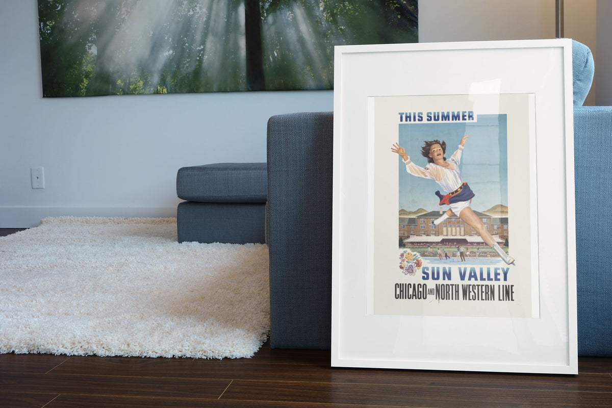 Sun Valley Ice Skating poster leaning beside a blue sofa