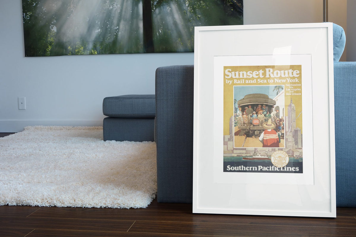 Sunset Route Southern Pacific poster leaning beside a blue sofa