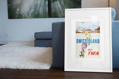 Switzerland Fly TWA poster leaning beside a blue sofa