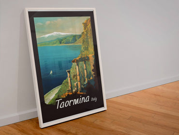Taormina, Italy poster in a white frame leaning against a wall