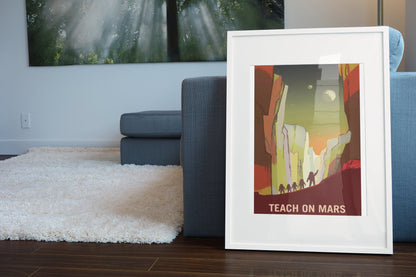 Teach on Mars poster in a white frame leaning beside a blue sofa