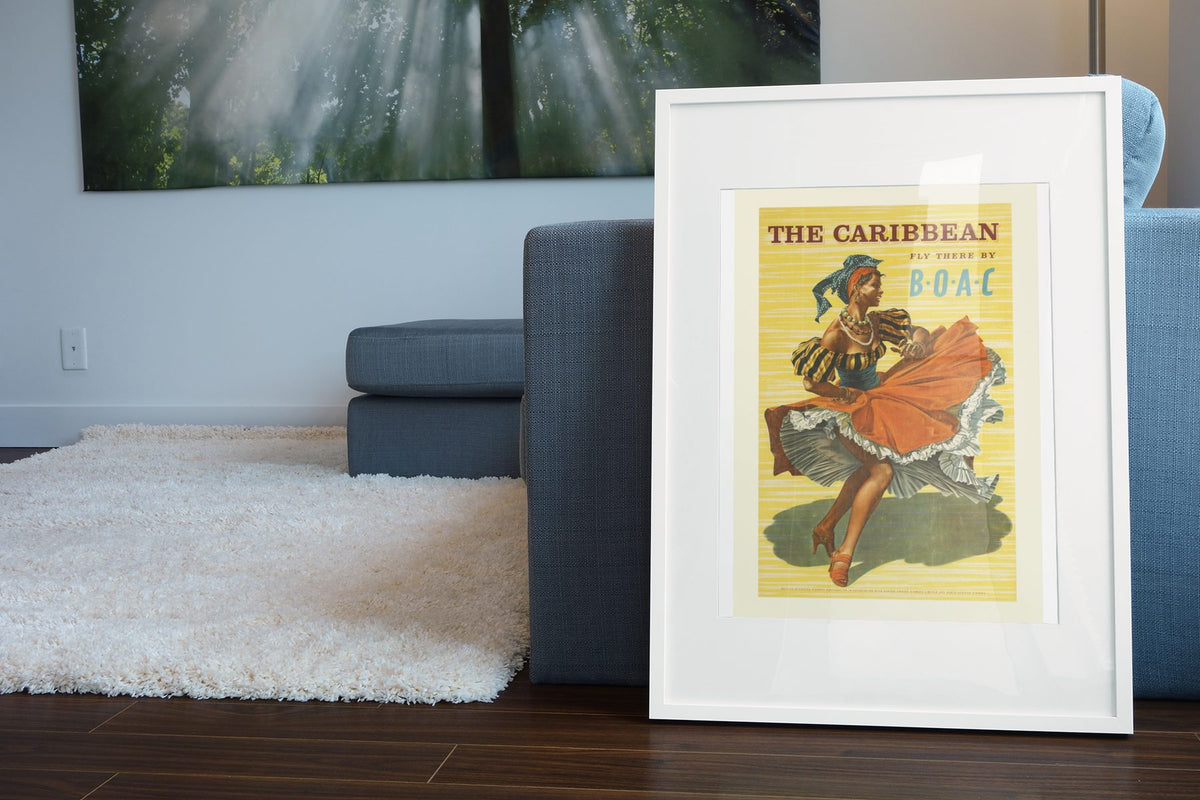 The Caribbean BOAC poster leaning beside a blue sofa