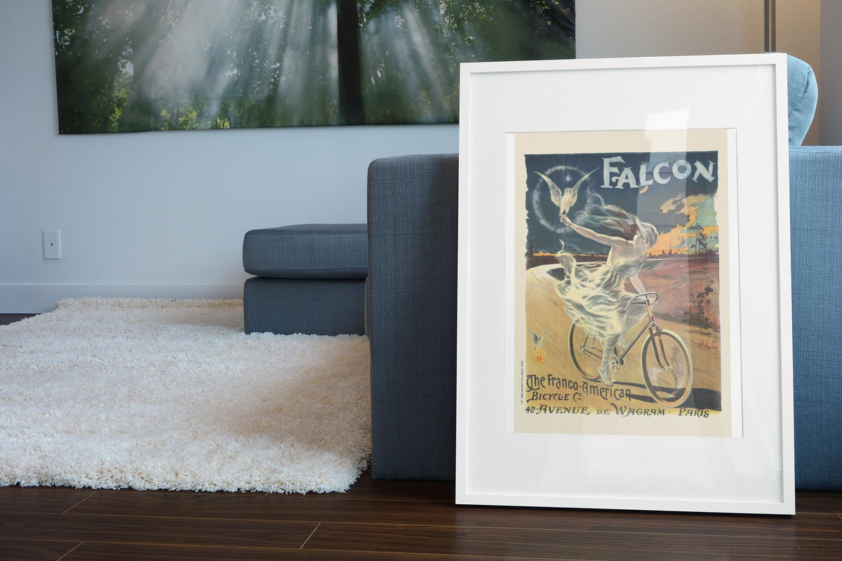 The Falcon Bicycle poster leaning beside a blue sofa