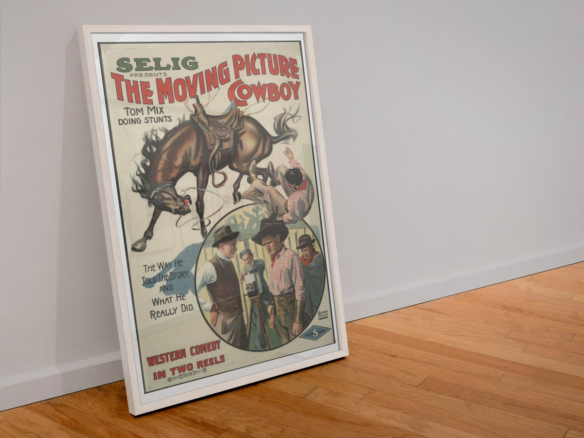 The Moving Picture Cowboy Tom Mix poster in a white frame leaning against a wall