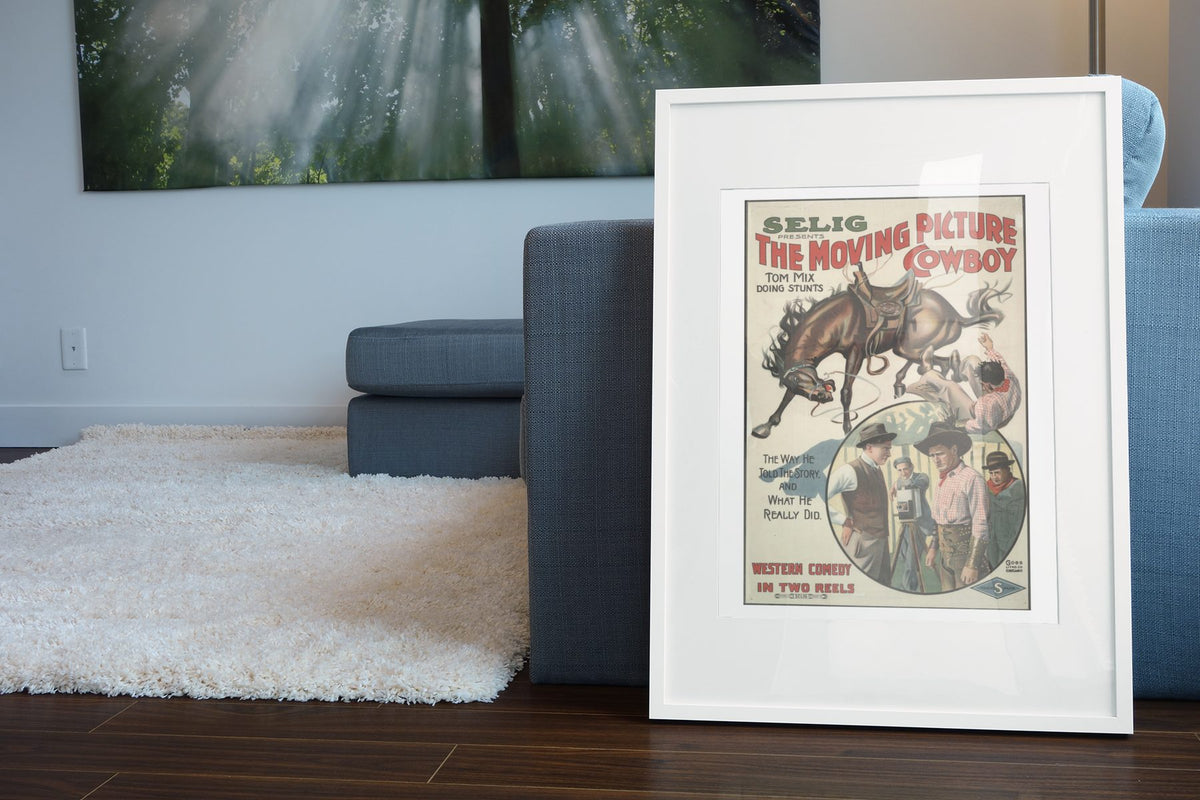 The Moving Picture Cowboy Tom Mix poster leaning beside a blue sofa