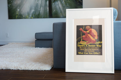 There’s a Better Way poster in a white frame leaning beside a blue sofa
