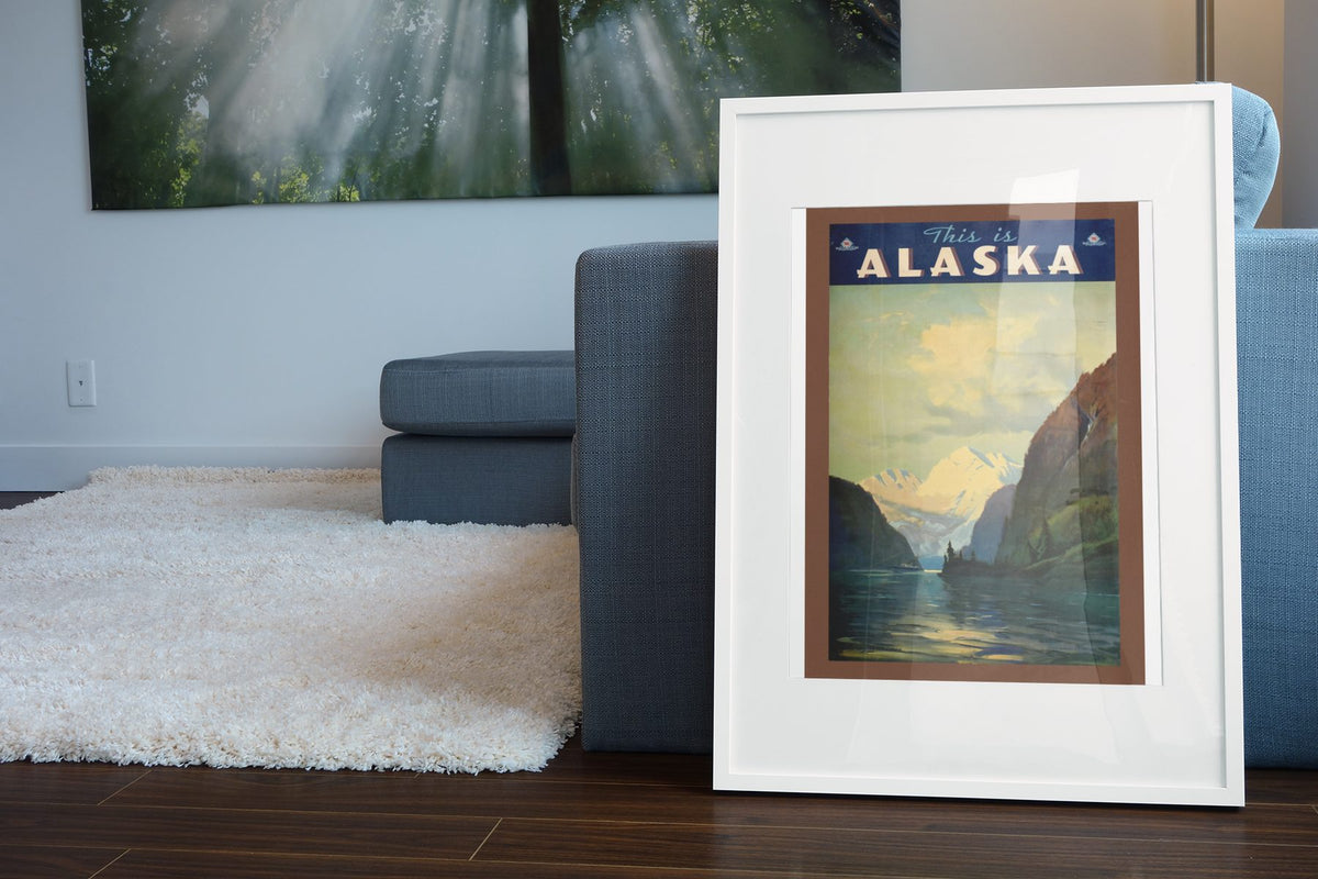 This Is Alaska poster leaning beside a blue sofa