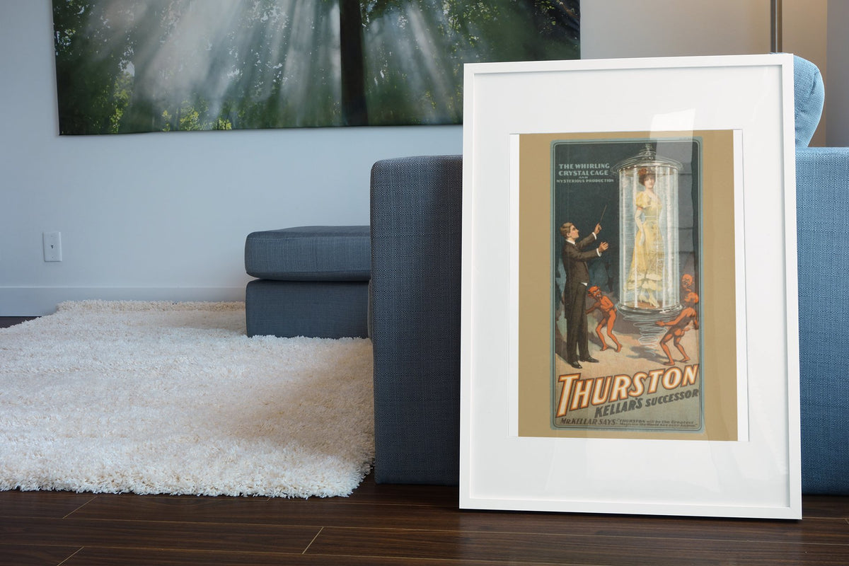 Thurston Whirling Crystal Cage poster leaning beside a blue sofa