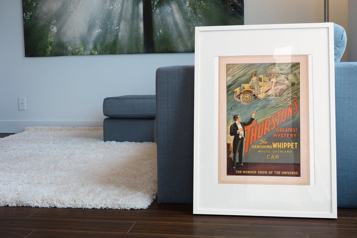 Thurston Vanishing Whippet Car poster leaning beside a blue sofa