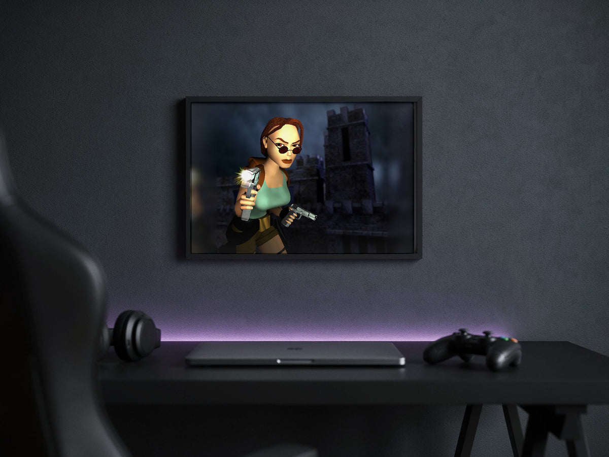 Tomb Raider III Key Art poster in a black frame above a gaming desk