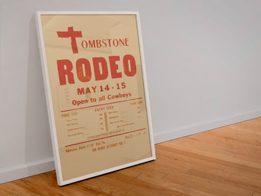 Tombstone Rodeo Open to All Cowboys poster in a white frame leaning against a wall