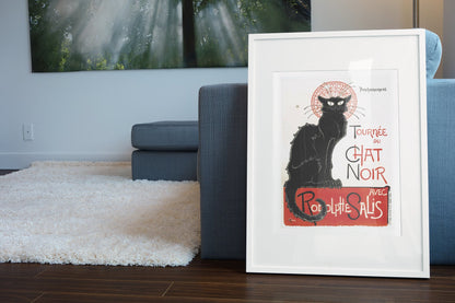 Tournée du Chat Noir 1896 black cat poster in a white frame leaning beside a blue sofa
