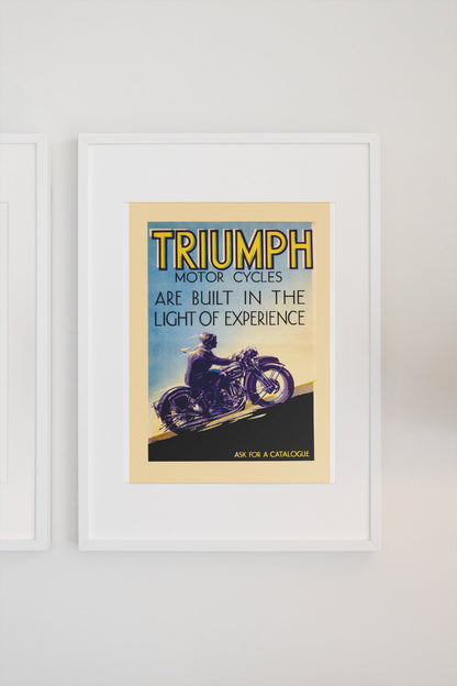 Triumph Motorcycles poster in a white frame on a light wall