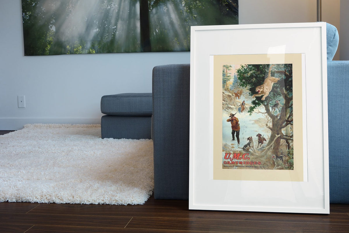 UMC Cartridges Bear Hunt poster leaning beside a blue sofa