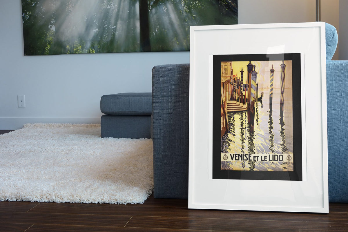 Venise et le Lido poster leaning beside a blue sofa