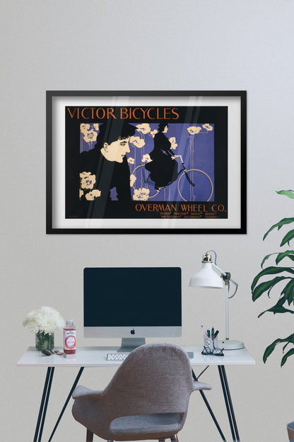 Victor Bicycles poster framed on a grey wall above a desk