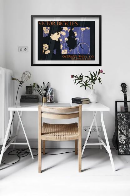 Victor Bicycles poster framed above a desk in a bright white room