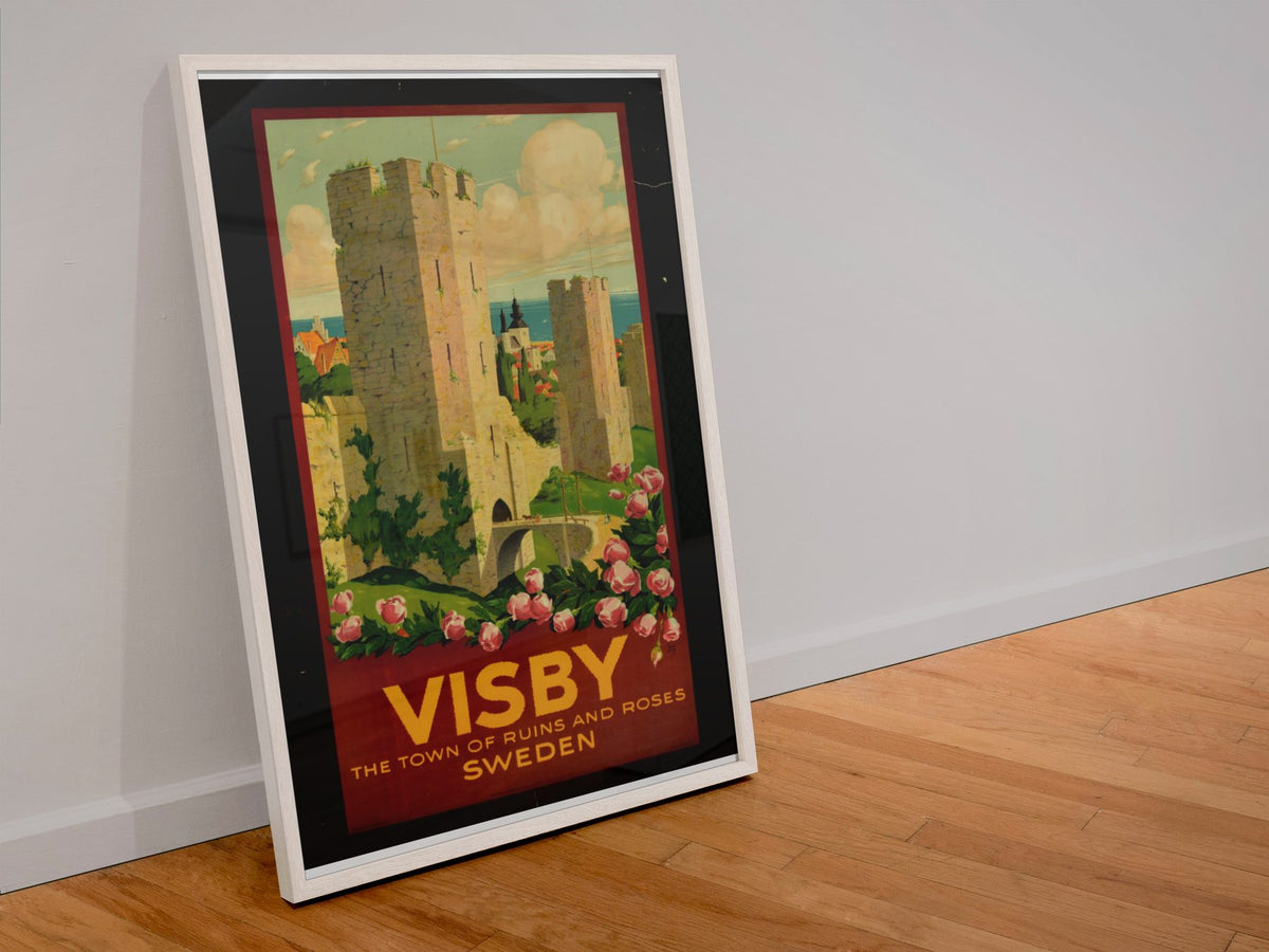 Visby — Town of Ruins and Roses poster in a white frame leaning against a wall