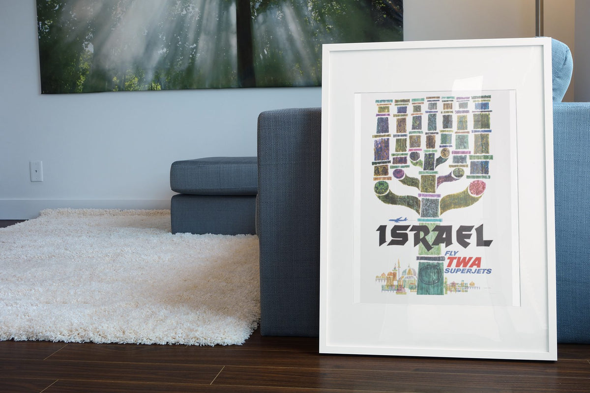 Visit Israel Fly TWA poster leaning beside a blue sofa