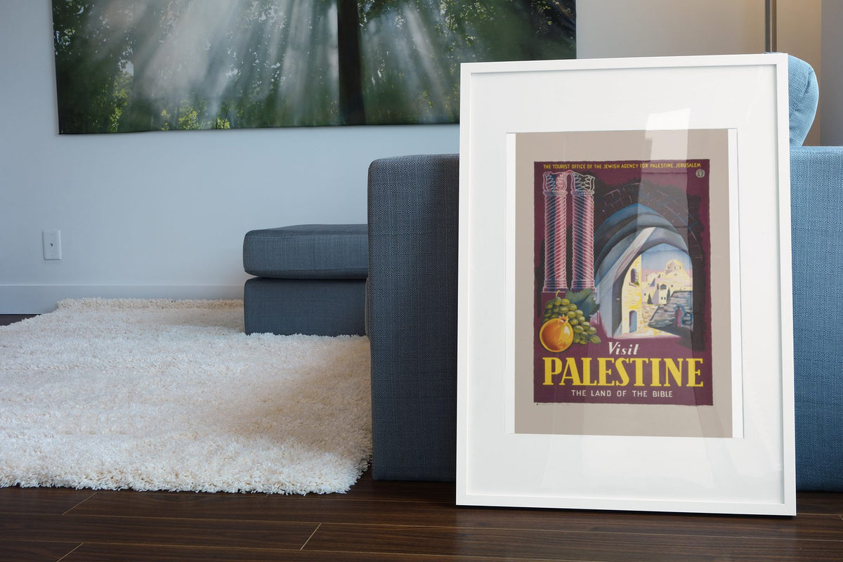 Visit Palestine Land of the Bible poster leaning beside a blue sofa