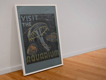 Visit the Aquarium Jellyfish poster in a white frame leaning against a wall