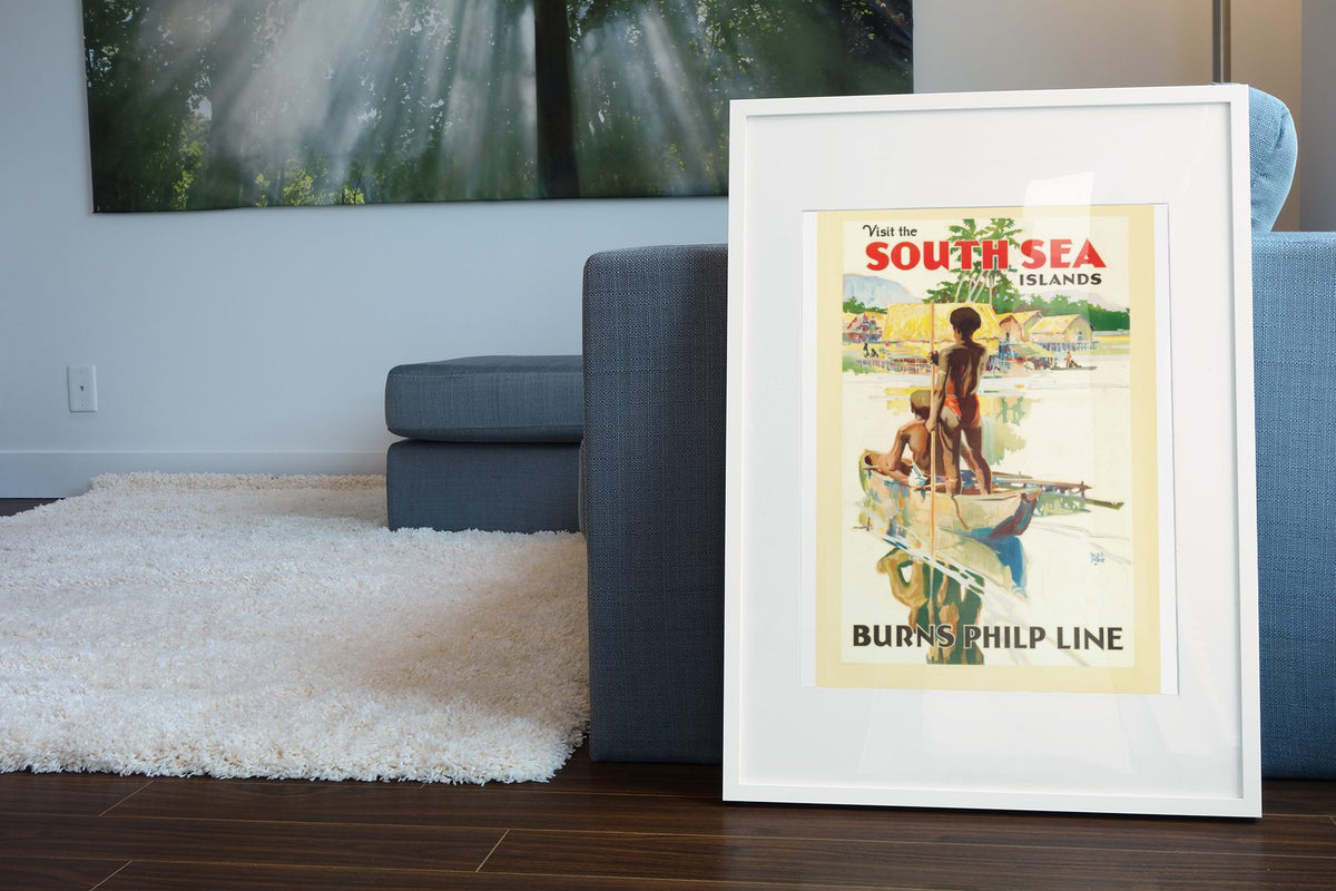 Visit South Sea Islands Burns Philp poster leaning beside a blue sofa