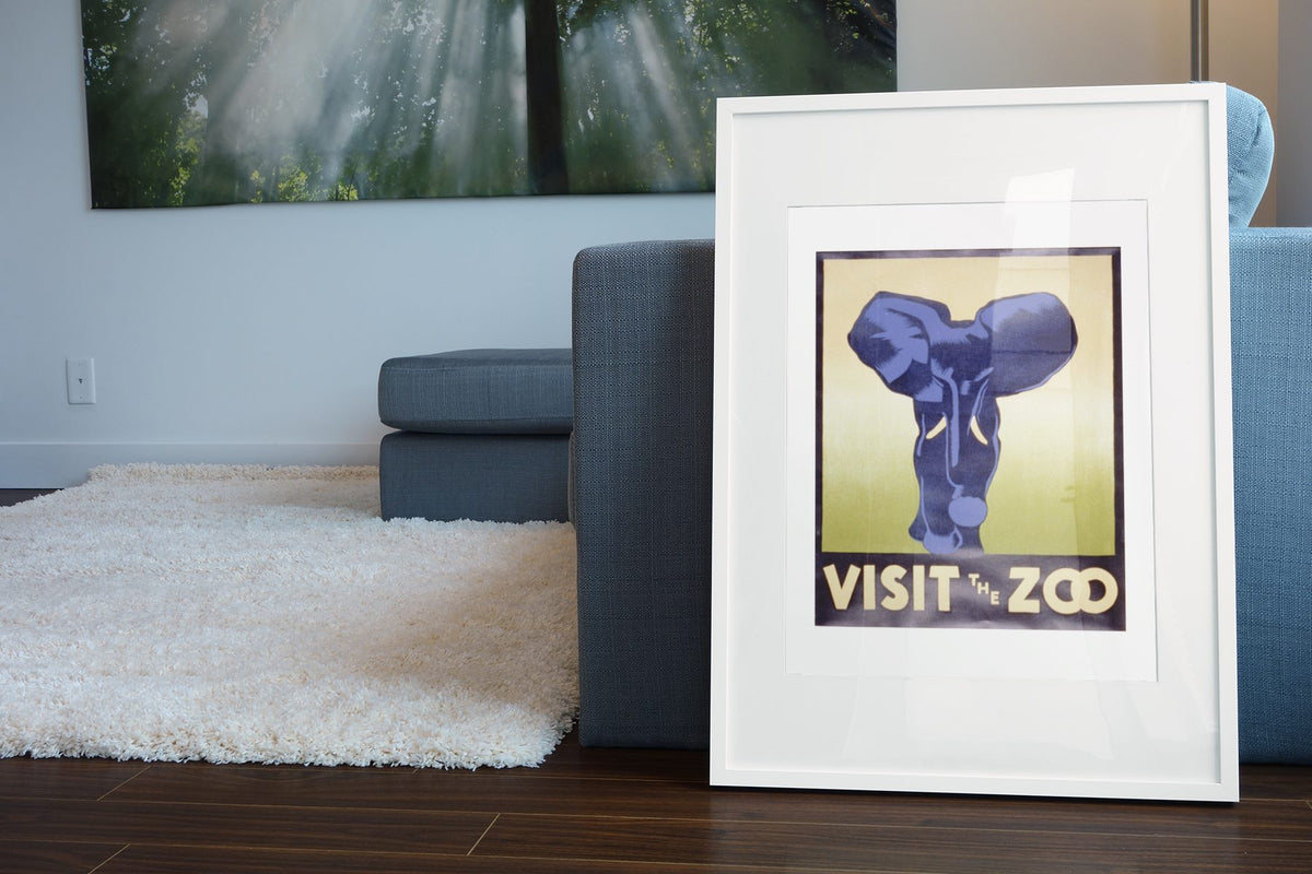 Visit the Zoo Elephant poster leaning beside a blue sofa