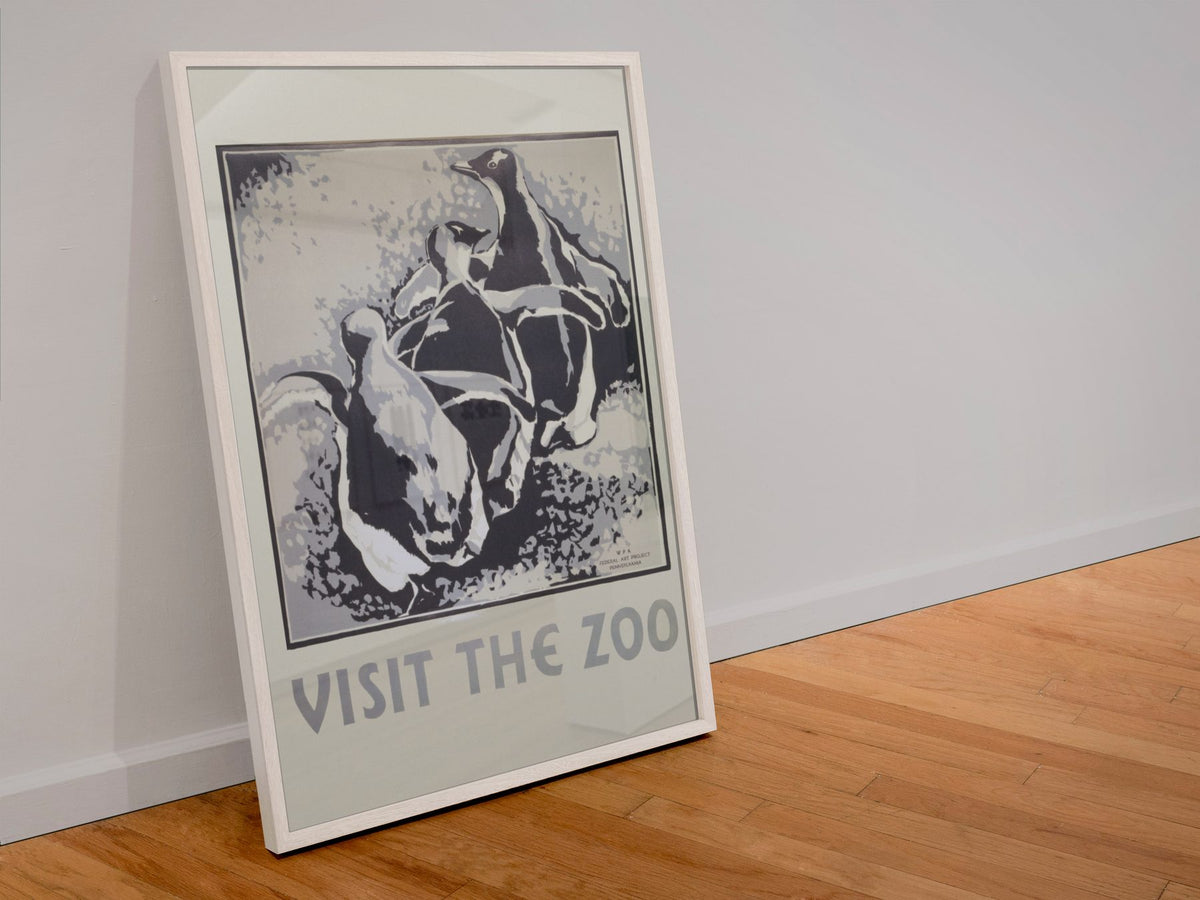 Visit the Zoo Penguins poster in a white frame leaning against a wall