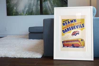 Ward Beam's Auto Daredevils poster in a white frame leaning beside a blue sofa