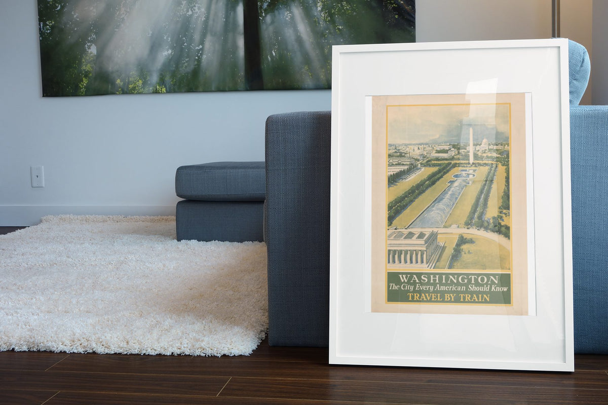 Washington Travel by Train poster leaning beside a blue sofa