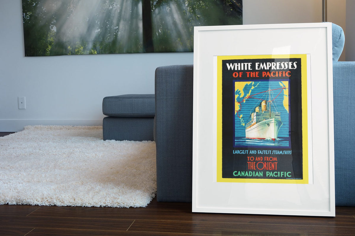 White Empresses of the Pacific poster leaning beside a blue sofa