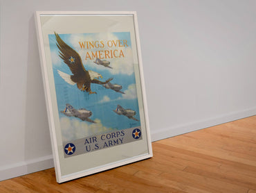 Wings Over America Air Corps US Army poster in a white frame leaning against a wall