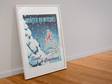 Winter Bewitches Greyhound poster in a white frame leaning against a wall