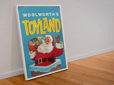 Woolworths Toyland Santa poster in a white frame leaning against a wall