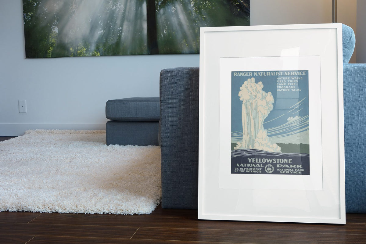Yellowstone Old Faithful WPA poster leaning beside a blue sofa