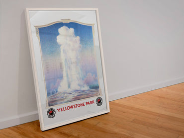 Yellowstone Old Faithful poster in a white frame leaning against a wall