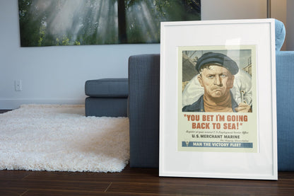 You Bet Im Going Back to Sea Merchant Marine poster leaning beside a blue sofa
