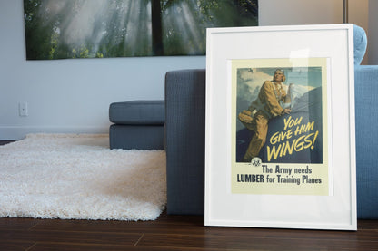 You Give Him Wings — Lumber for Training Planes poster leaning beside a blue sofa